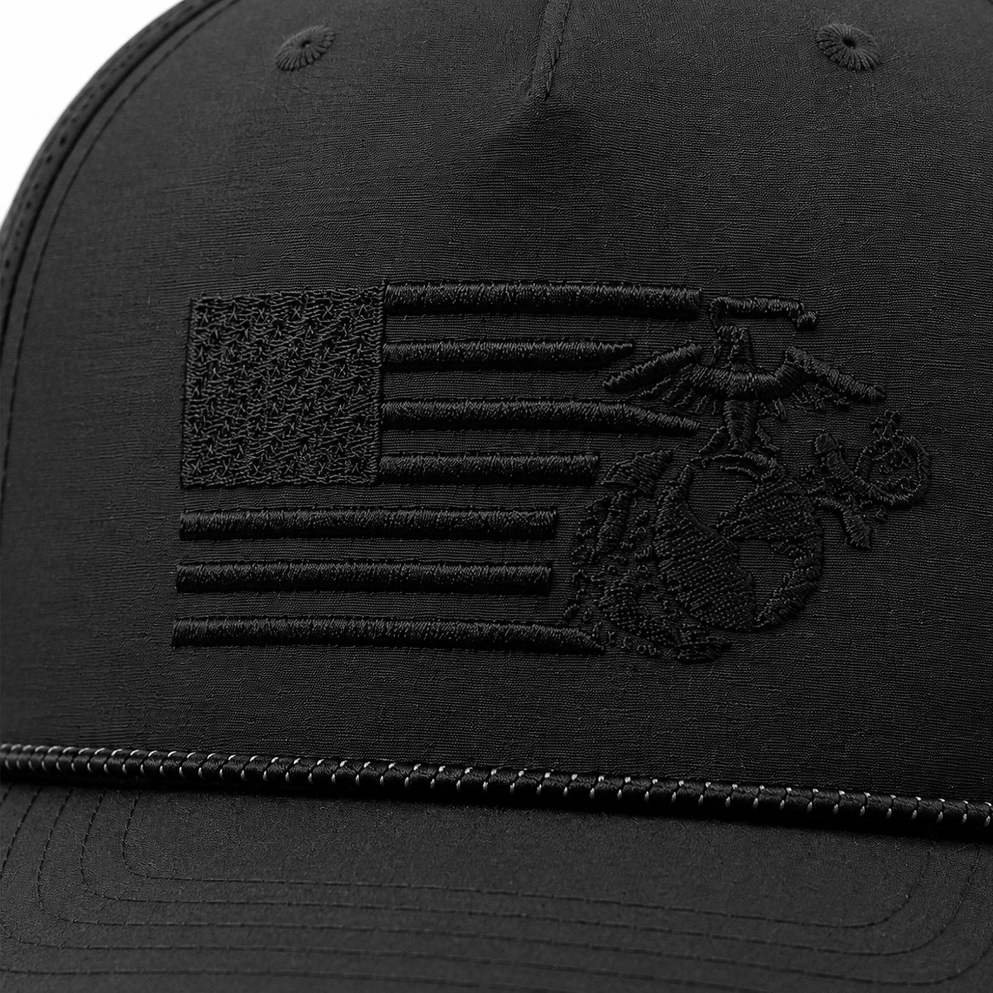 Black USMC laser perforated performance rope cap with black-on-black embroidered split American flag and Eagle, Globe, and Anchor design on the front. Marine Corps Cover. USMC black hat